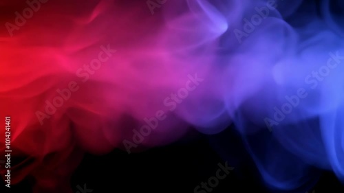Soft swirls of red and blue smoke intertwine in a mesmerizing dance against a black background creating a vivid and abstract visual of colors in motion.