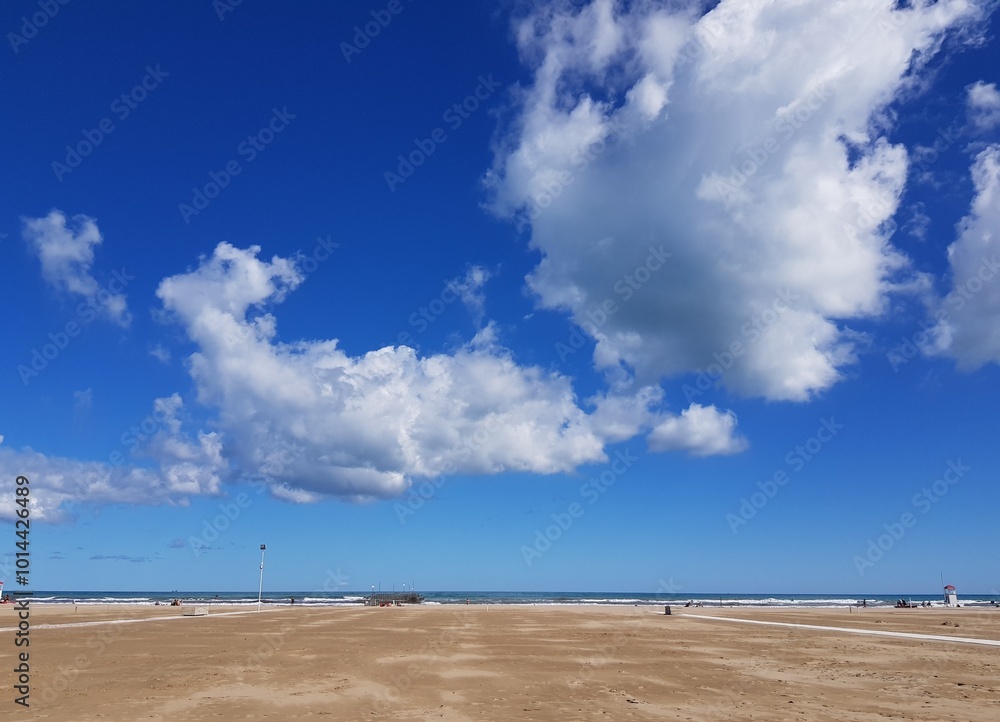 View of the beach and blue sky with white cumulus clouds. View of the beach and blue sky with white cumulus clouds.