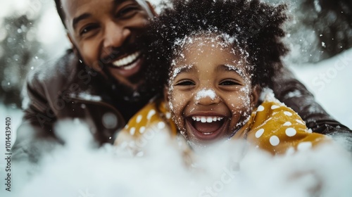 Amidst snowfall, a father and daughter laugh heartily, their joy captured in their expressions as snowflakes dot their faces and the snowy backdrop enchants the view. photo