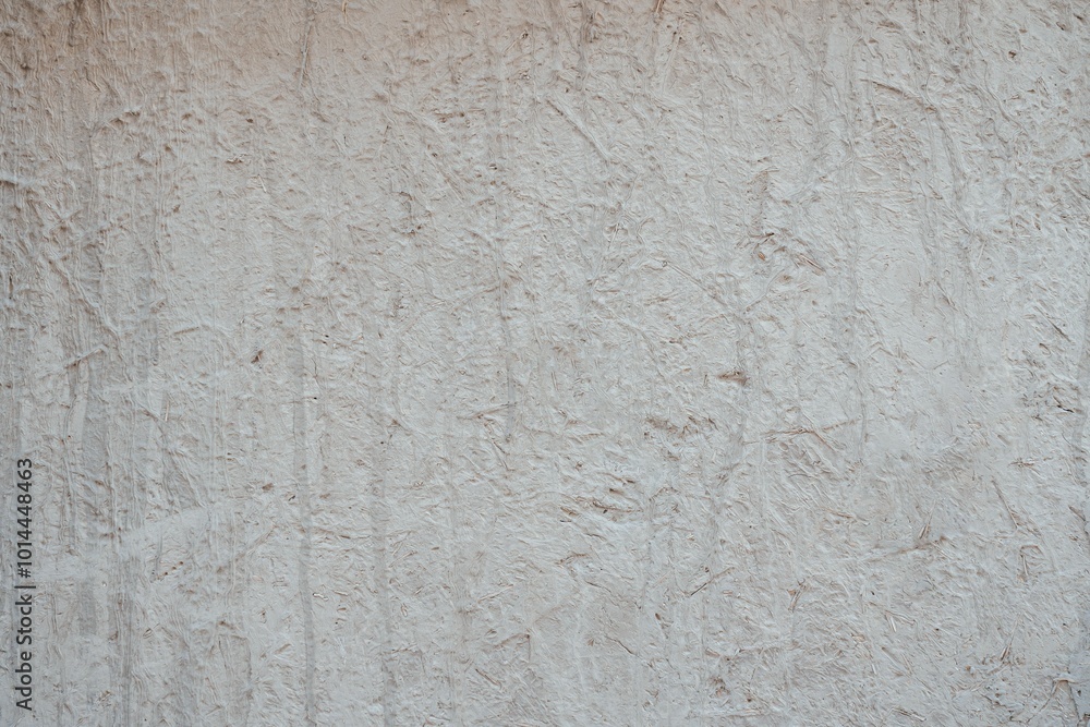 Fototapeta premium Textured Plaster Wall Background. A close-up of a textured plaster wall with an abstract rough surface. The neutral light beige color and irregular patterns create a natural and artistic backdrop. 