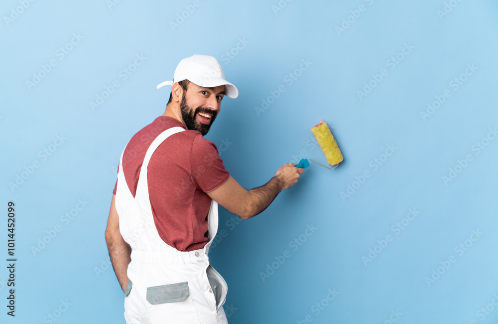 Adult painter man over isolated blue background Adult painter man over isolated blue background