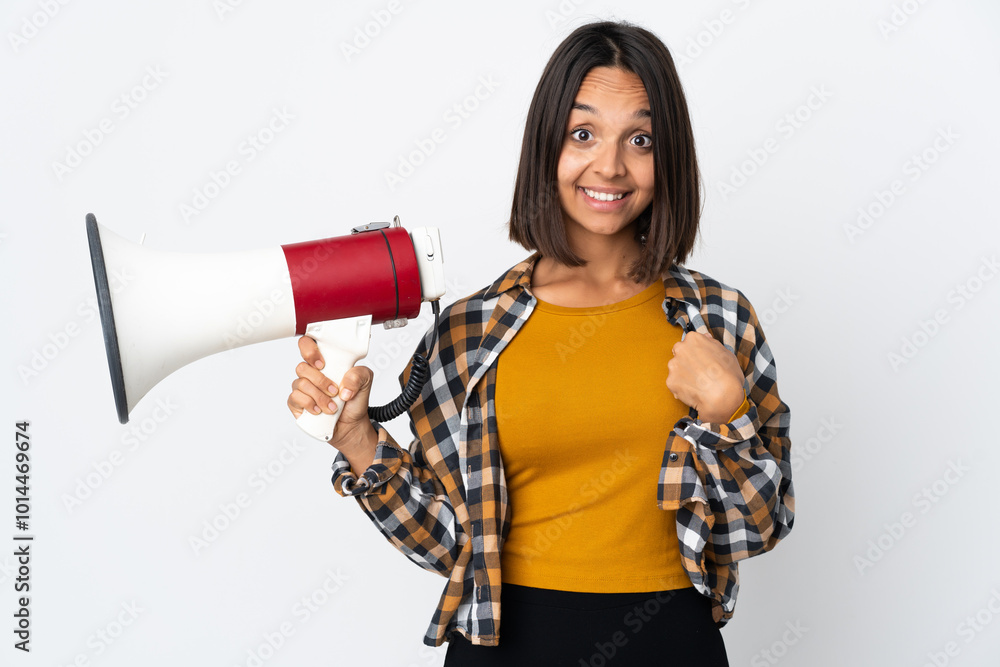 Young latin woman isolated on white background holding a megaphone and with surprise facial expression Young latin woman isolated on white background holding a megaphone and with surprise facial expression
