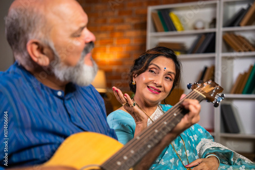 A retired couple creates beautiful memories as the husband plays guitar while his wife sings photo