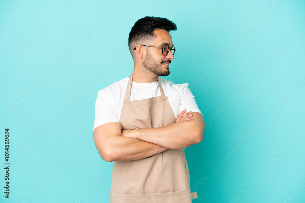 Restaurant waiter caucasian man isolated on blue background looking side Restaurant waiter caucasian man isolated on blue background looking side