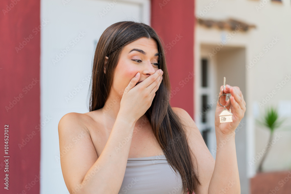 Young pretty Brazilian woman at outdoors holding home keys Young pretty Brazilian woman at outdoors holding home keys