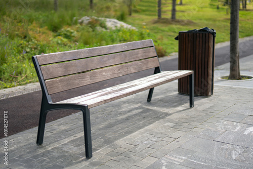 wooden and metal bench alongside a matching trash bin on the sidewalk, symbolizing urban design and public space interaction, promoting sustainability and community engagement