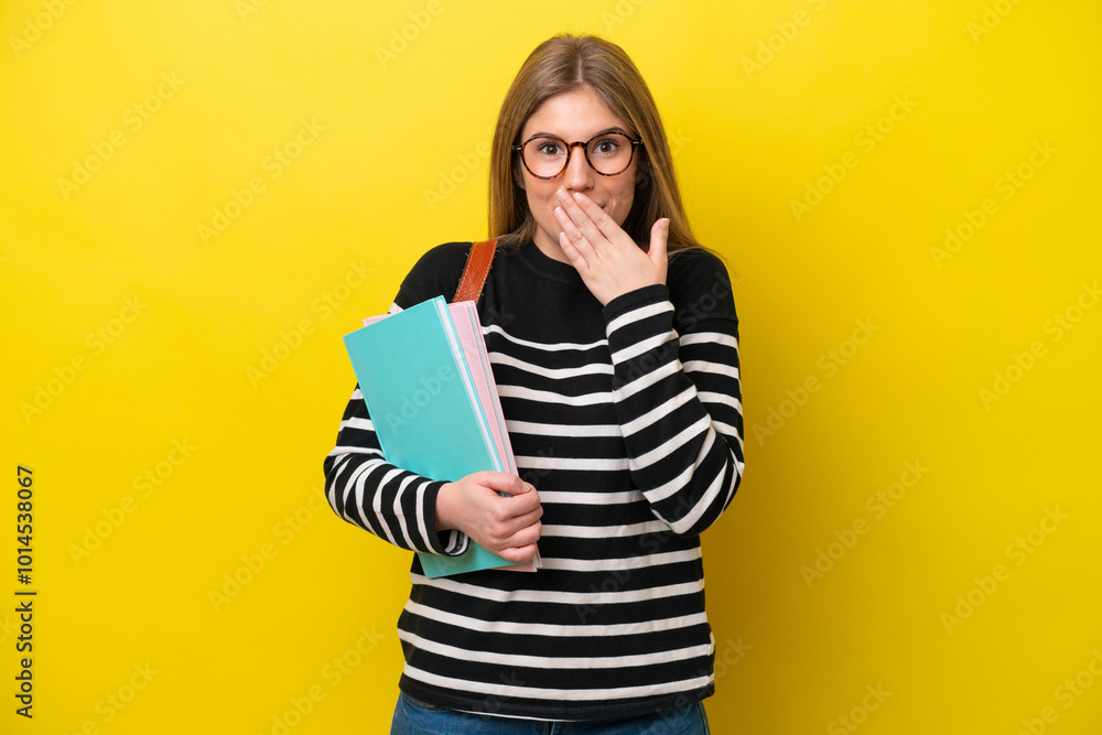Young student woman isolated on yellow background background happy and smiling covering mouth with hand Young student woman isolated on yellow background background happy and smiling covering mouth with hand