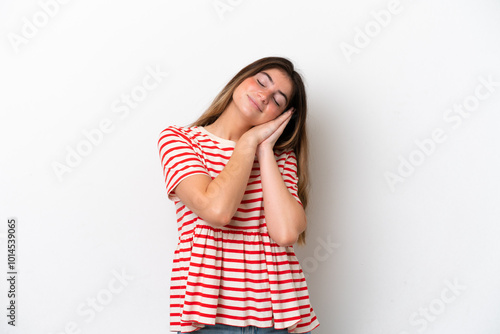 Young caucasian woman isolated on white background making sleep gesture in dorable expression photo