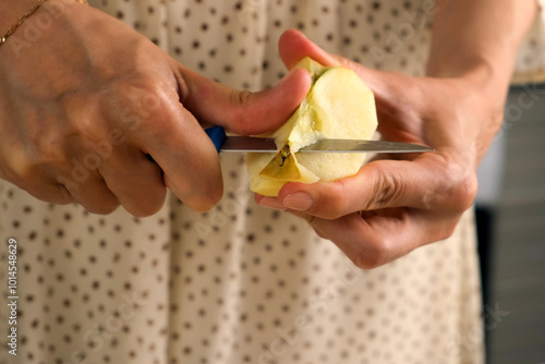 Woman peeling cutting apples cooking dish on kitchen at home, hands close-up. Female housewife in dress preparing dish from apples. Culinary, cuisine, healthy eating, baking concept.