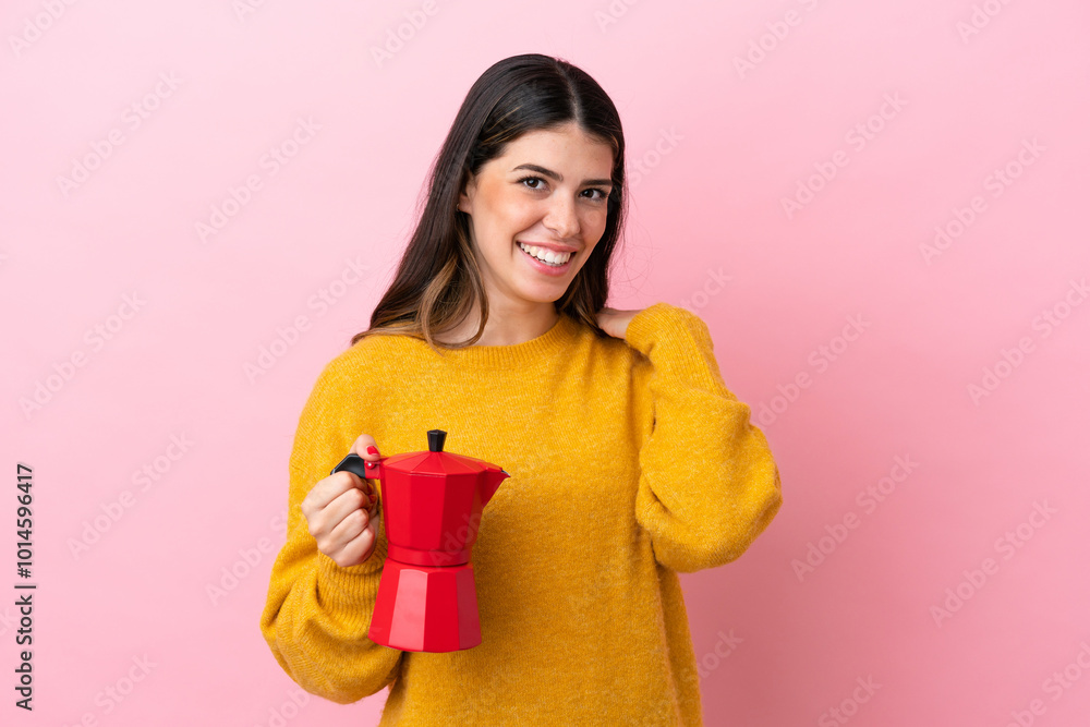 Young Italian woman holding a coffee maker isolated on pink background laughing Young Italian woman holding a coffee maker isolated on pink background laughing