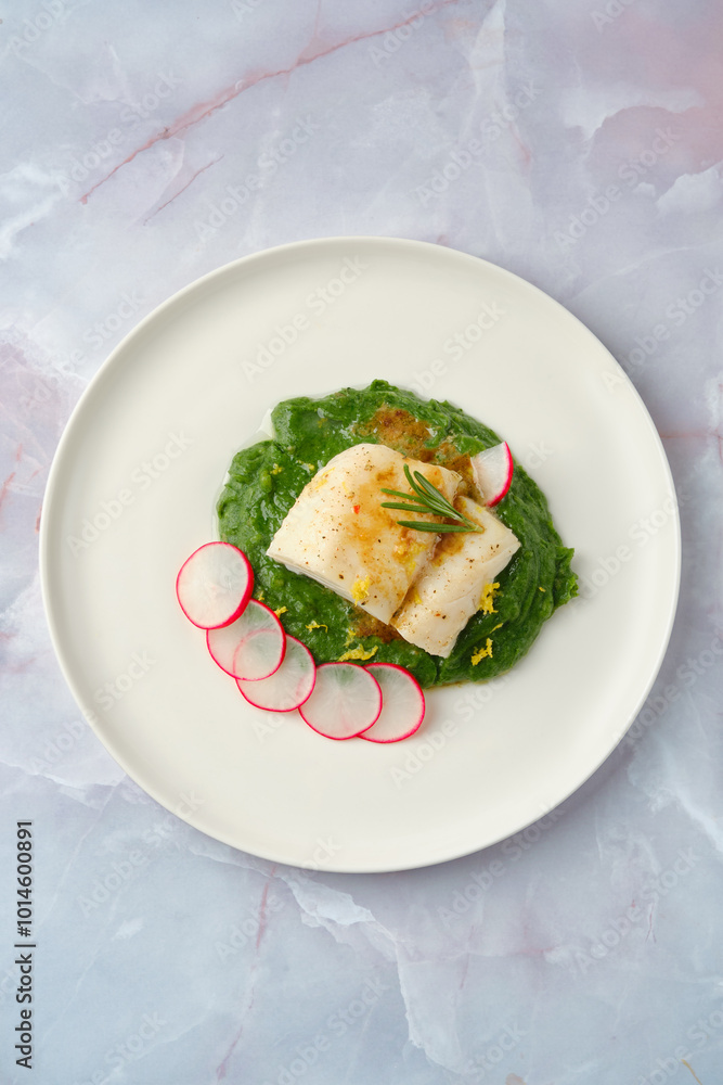 Elegant white cod fish served on vibrant spinach puree with sliced radishes, garnished for visual appeal Elegant white cod fish served on vibrant spinach puree with sliced radishes, garnished for visual appeal