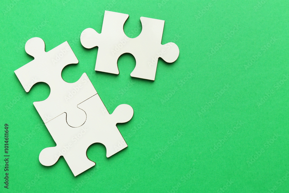 Obraz premium White puzzle pieces on green background, top view. Space for text