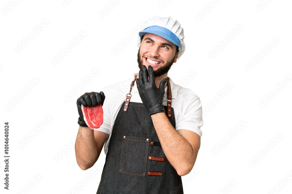 Butcher man wearing an apron and serving fresh cut meat over isolated chroma key background looking up while smiling Butcher man wearing an apron and serving fresh cut meat over isolated chroma key background looking up while smiling