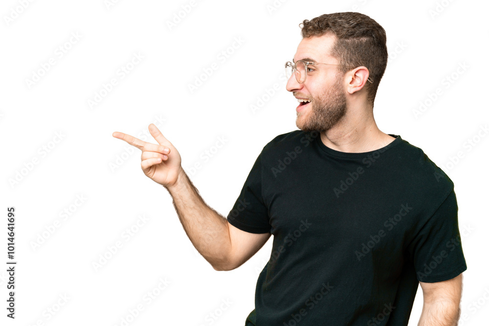 Young handsome blonde man over isolated chroma key background pointing finger to the side and presenting a product