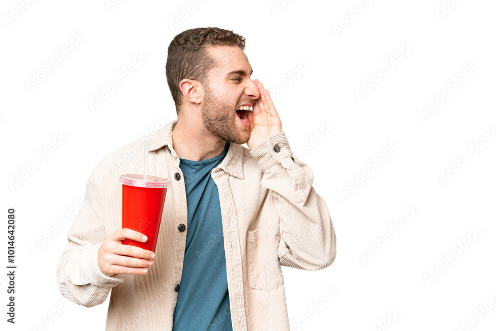 Young handsome blonde man holding soda over isolated chroma key background shouting with mouth wide open to the side Young handsome blonde man holding soda over isolated chroma key background shouting with mouth wide open to the side