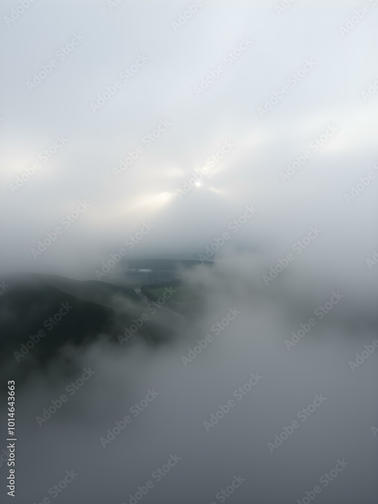 A soft, overcast sky with rolling fog moving across the landscape, creating a mysterious, dreamy atmosphere with light breaking through in soft beams