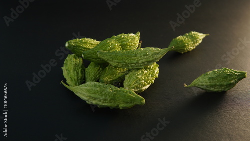 Momordica charantia fruit or (Peria, Bitter Gourd, Bitter Melon, Bitter Cucumber, Balsam Pear, Leprosy Gourd, Pare) on a black background photo