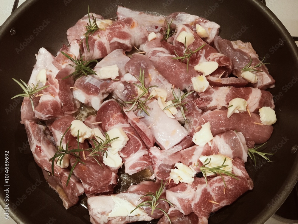 mixed pork meat cooked in a pan with rosemary and sage, butter, oil and salt