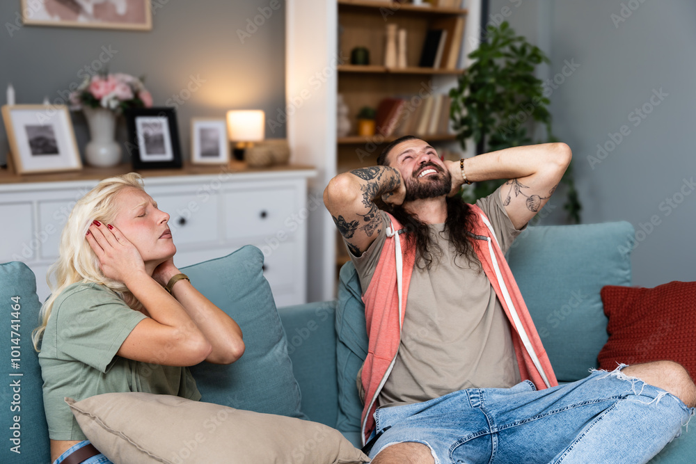 Φωτογραφία Young couple stares at the ceiling and yells because a neighbor upstairs is having a party with loud music or renovating an apartment and workers are drilling with heavy tools