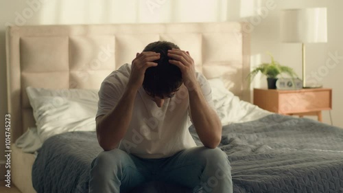Unhappy Caucasian European man holding head problem crisis breakup male guy bedroom credit debt serious trouble hopelessness depressed grief despair difficulty disappointment sadness emotional stress