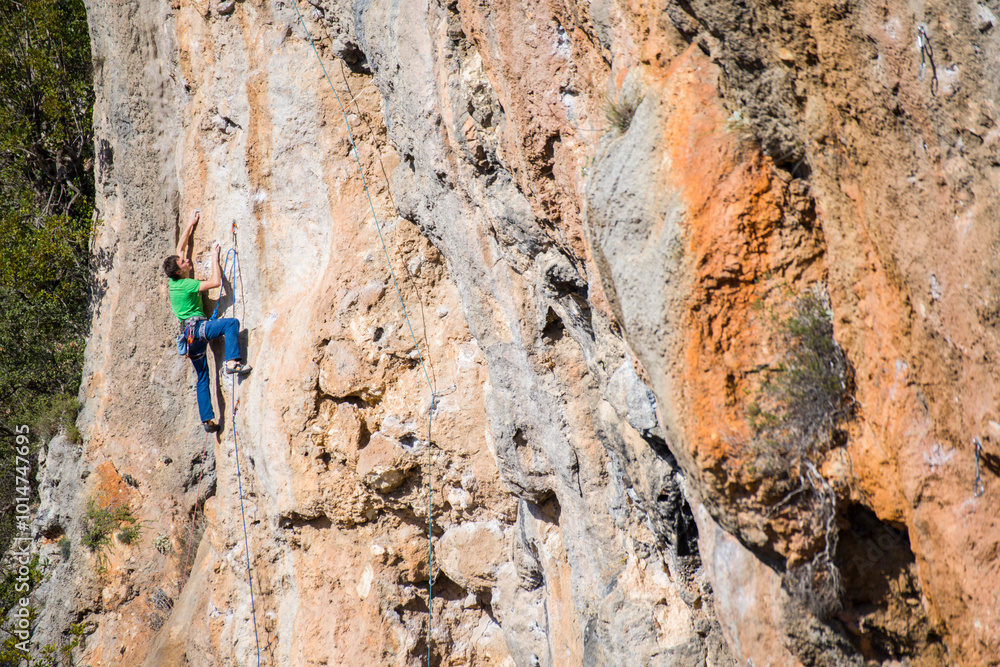 A rock climber ascends to the summit via a difficult route. A rock climber ascends to the summit via a difficult route.