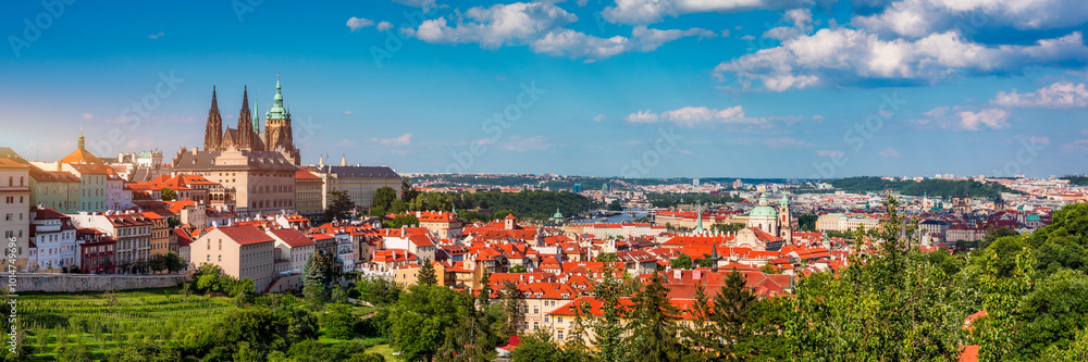 Obraz premium View of Prague featuring historic castle and vibrant rooftops on a sunny day in summer. Aerial view of Prague, Charles Bridge over Vltava river in Prague, Czechia. Old Town of Prague, Czech Republic.