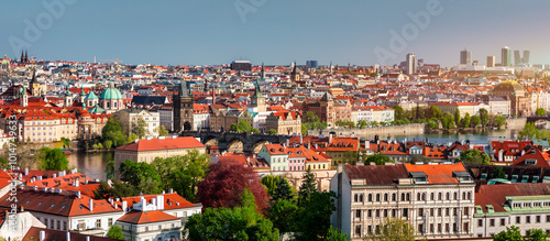 View of Prague featuring vibrant rooftops on a sunny day in summer. Aerial view of Prague, Charles Bridge over Vltava river in Prague, Czechia. Old Town of Prague, Czech Republic.