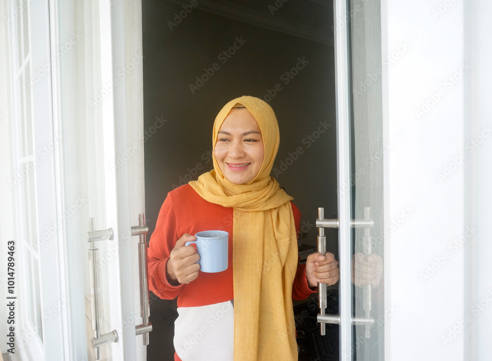 Smiling Asian Woman Holds Cup Of Coffee And Opening Door At Balcony Smiling Asian Woman Holds Cup Of Coffee And Opening Door At Balcony