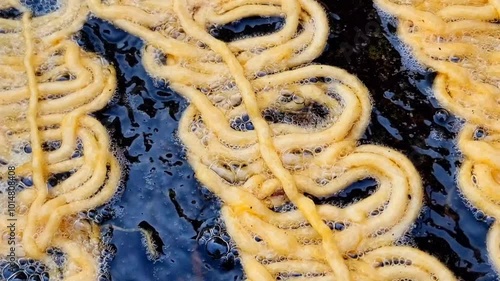 Person Making Jalebi in Hot Oil, Traditional Indian Sweet Preparation, Capturing the Art of Street Food and Culinary Craft