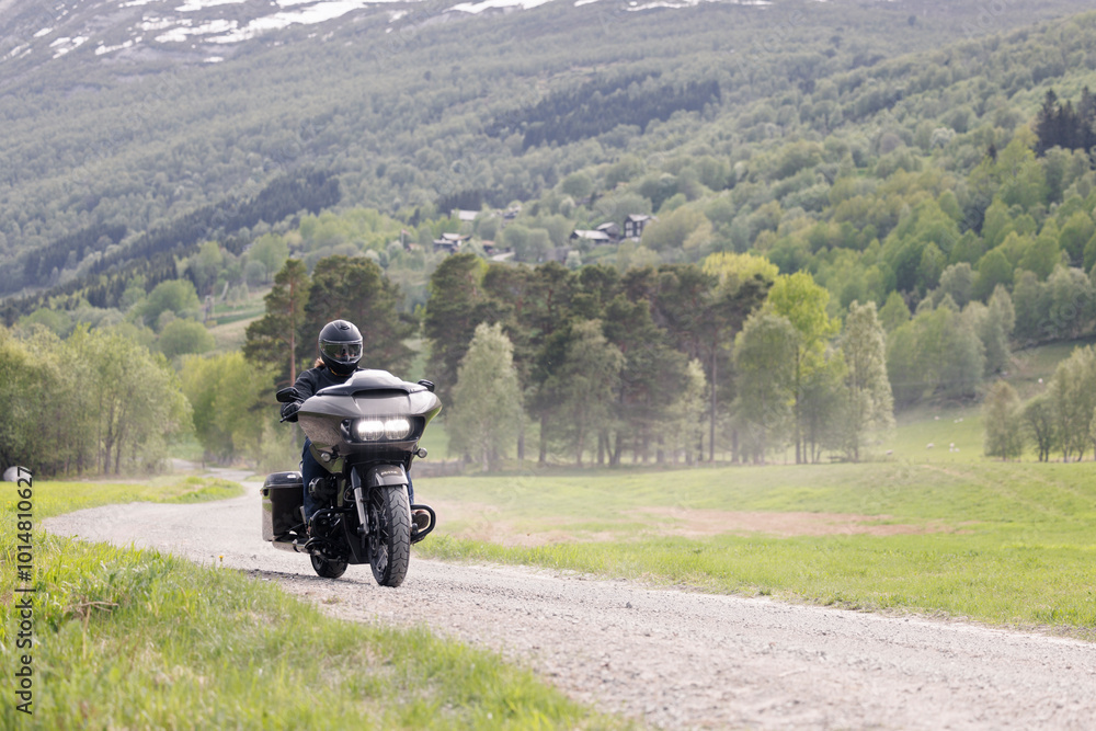 Person riding a motorcycle on gravel road. Person riding a motorcycle on gravel road.