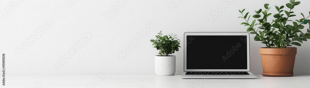 A modern workspace featuring a laptop and indoor plants, creating a calm and productive environment for work or study. A modern workspace featuring a laptop and indoor plants, creating a calm and productive environment for work or study.