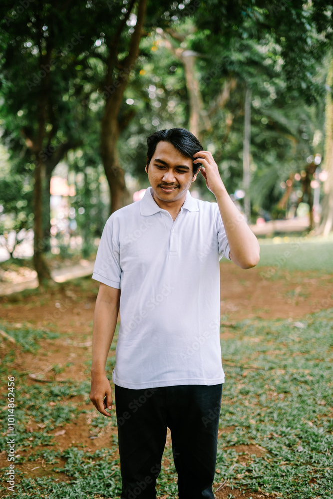 Southeast Asian man holding his head, expressing stress or deep thought. Southeast Asian man holding his head, expressing stress or deep thought.