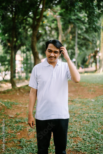 Southeast Asian man holding his head, expressing stress or deep thought.