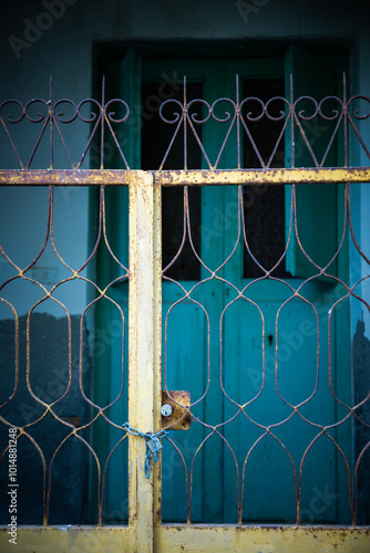 Close up shot of a petrol blue door or teal colored entrance or front door with a golden handle in a mediterranean island. Summer vibes, italian style, aeolian tourism. photo