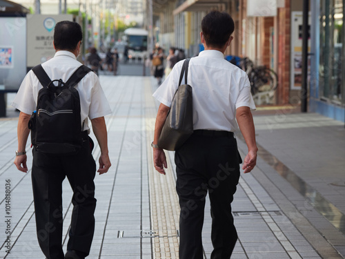 夏の朝の通勤時間で街を歩く人々の姿