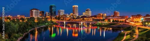 City skyline at dusk with colorful lights reflecting in the water.