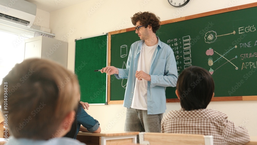 Professional mentor looking around classroom while standing in front of ...
