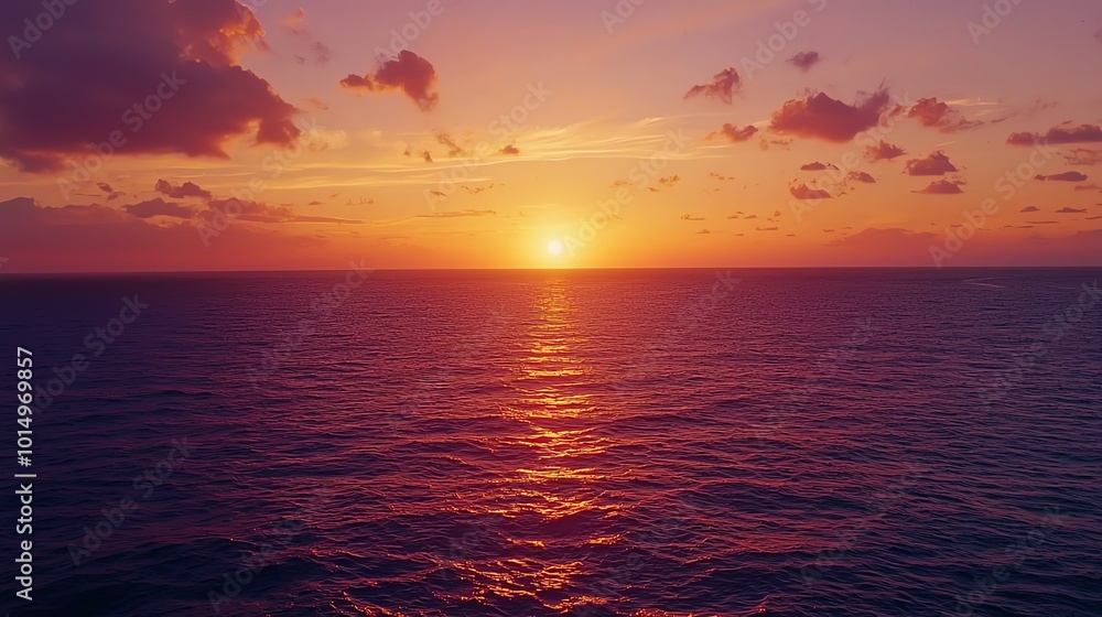 Obraz premium Sunset over calm ocean, sky ablaze with vibrant oranges and purples
