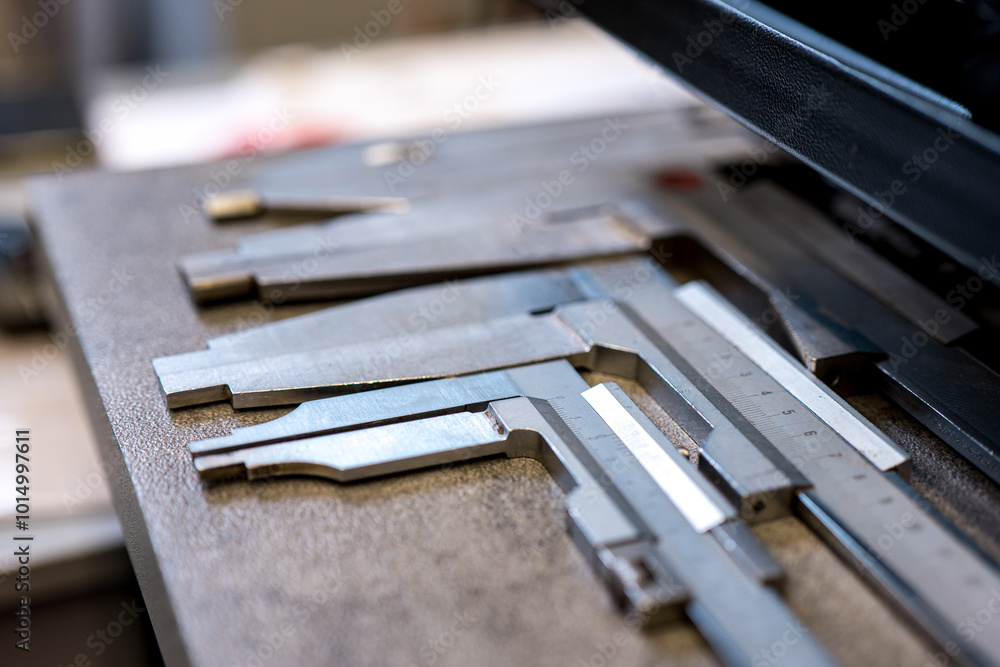 A close-up of several precision calipers lying on a wooden surface in a workshop A close-up of several precision calipers lying on a wooden surface in a workshop