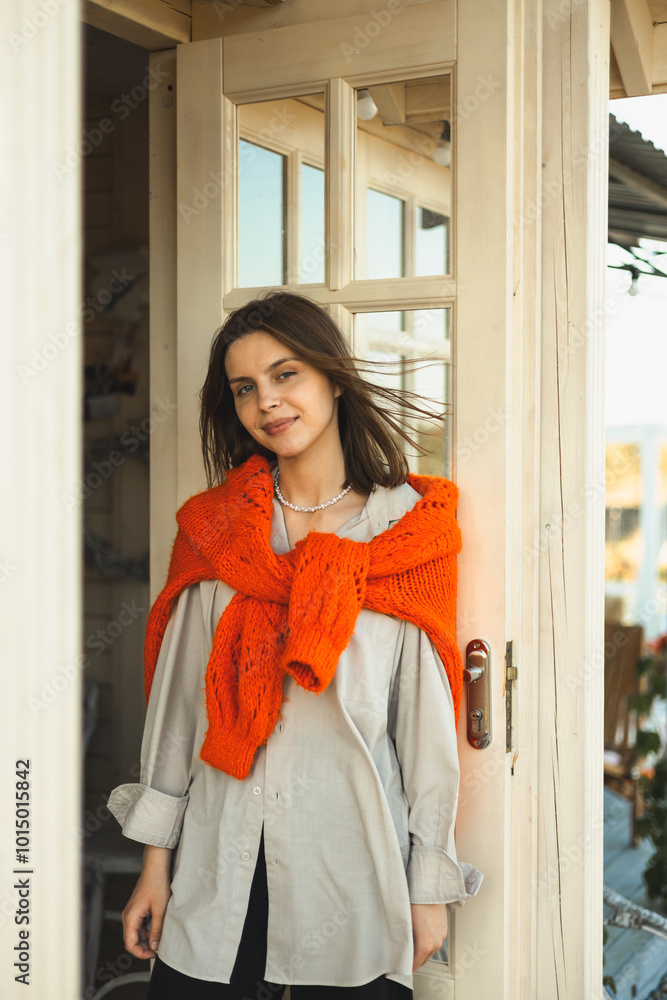 A girl is holding a pumpkin on the porch of her house. decorating houses for Halloween. Autumn home decor. Autumn mood A girl is holding a pumpkin on the porch of her house. decorating houses for Halloween. Autumn home decor. Autumn mood