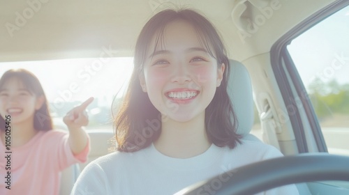 Two young Japanese women sit in the front seat of an electric car, pointing at something out the window as they drive on a highway.