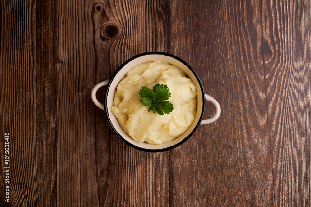 Freshly made bowl of mashed potatoes on a brown wooden table, top down view capturing the creamy texture and simplicity of homemade comfort food Freshly made bowl of mashed potatoes on a brown wooden table, top down view capturing the creamy texture and simplicity of homemade comfort food