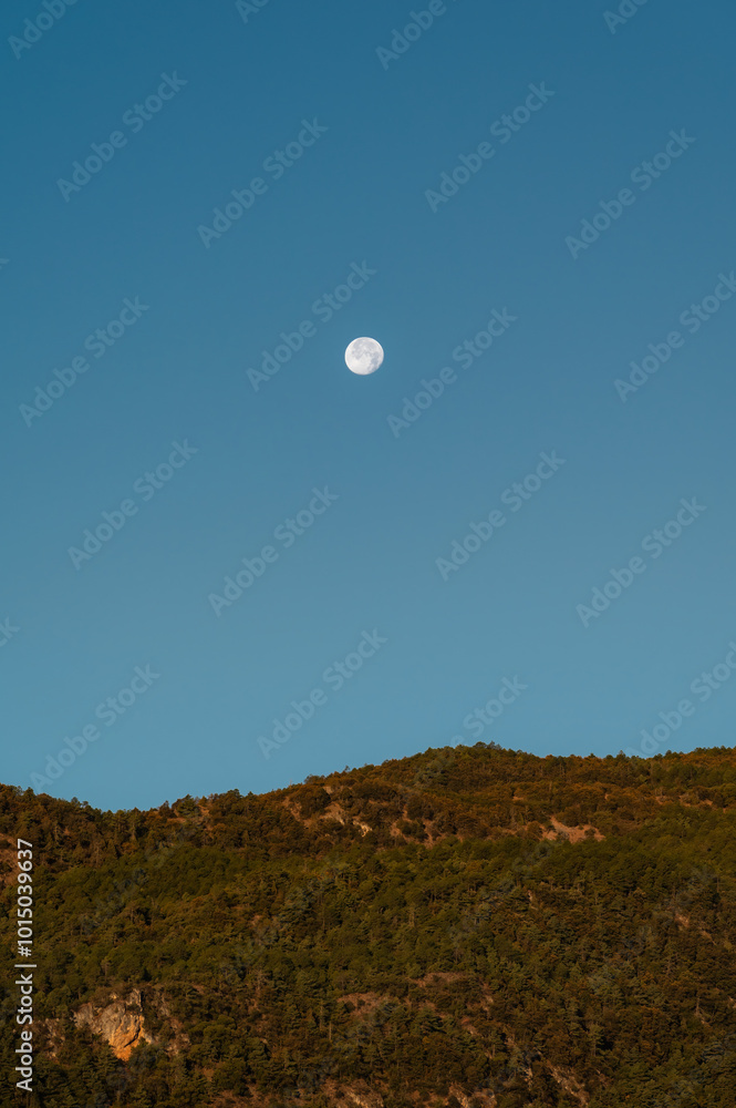 The moon above the mountaintop in the early morning The moon above the mountaintop in the early morning