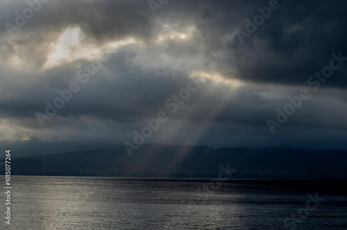 Sunlight through storm clouds over the Bali Straits in Indonesia.