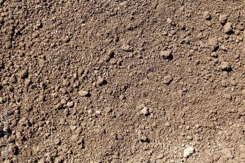 Texture of plowed smoothed brown soil.