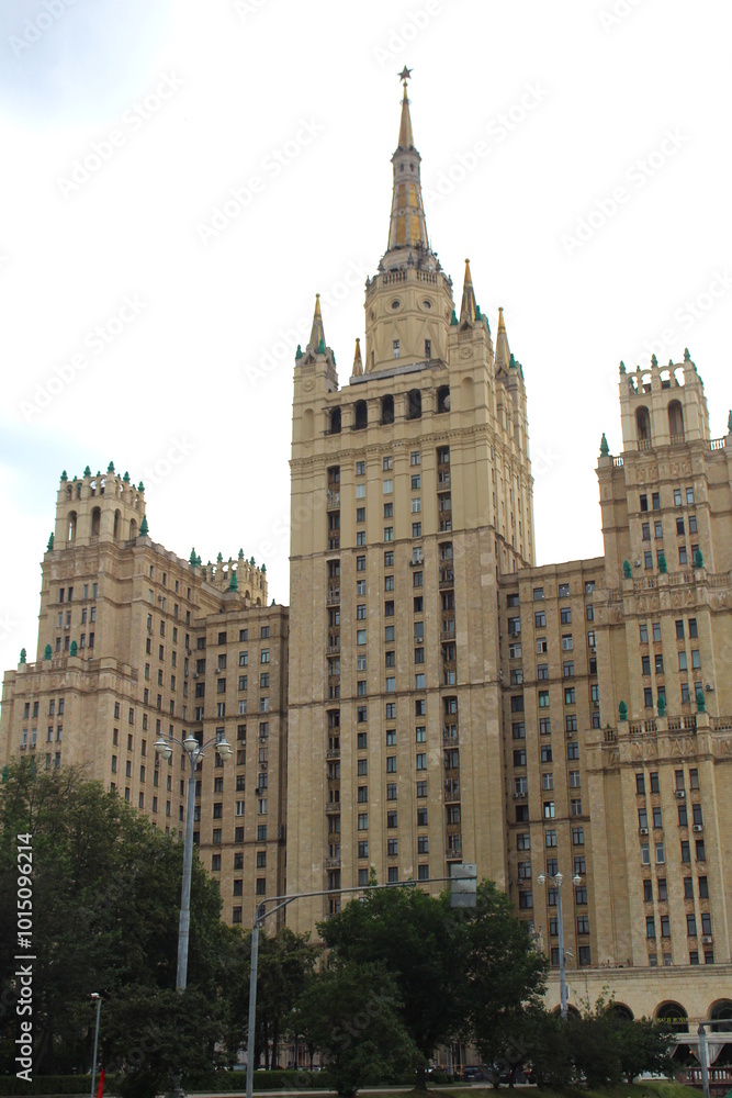 A tall building with a spire stands against a cloudy sky. A tall building with a spire stands against a cloudy sky.