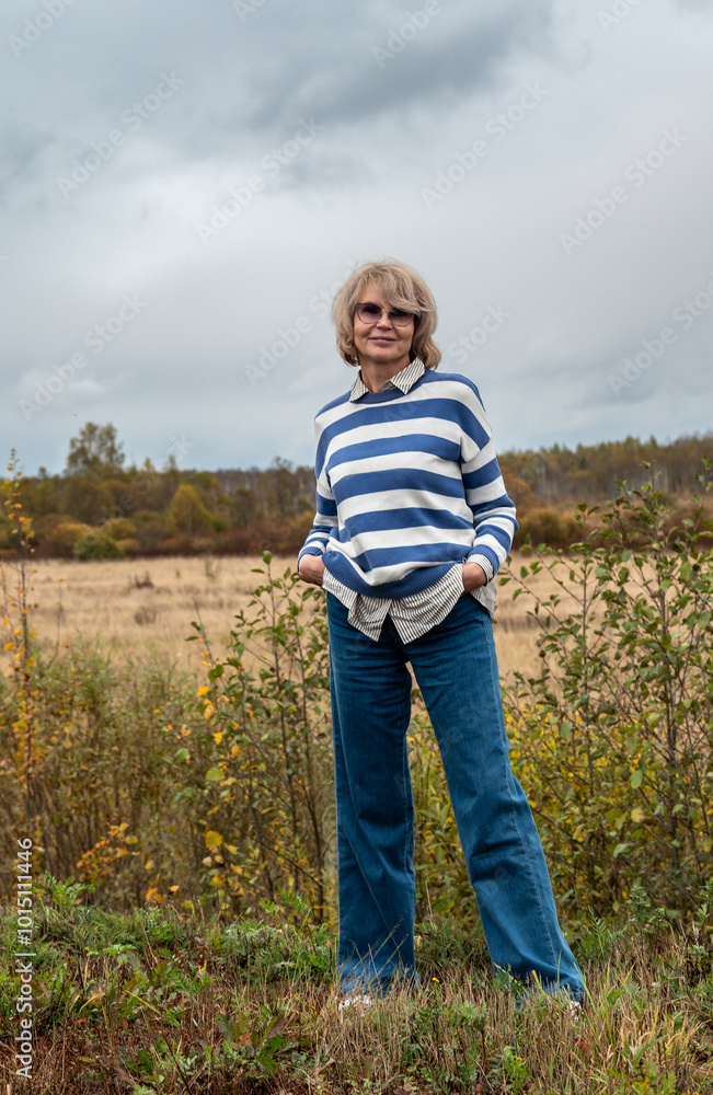 Portrait of a beautiful mature woman on background of autumn landscape. Portrait of a beautiful mature woman on background of autumn landscape.