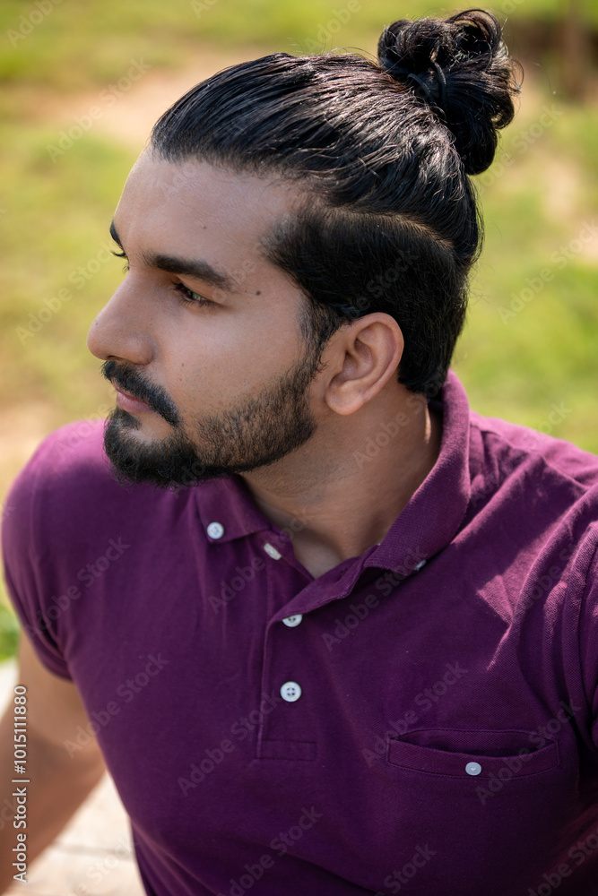 Close-up portrait of a confident, handsome, bearded Asian-Indian man with a ponytail. He's gazing into the distance, showing a range of facial expressions and exuding a calm demeanor. Close-up portrait of a confident, handsome, bearded Asian-Indian man with a ponytail. He's gazing into the distance, showing a range of facial expressions and exuding a calm demeanor.