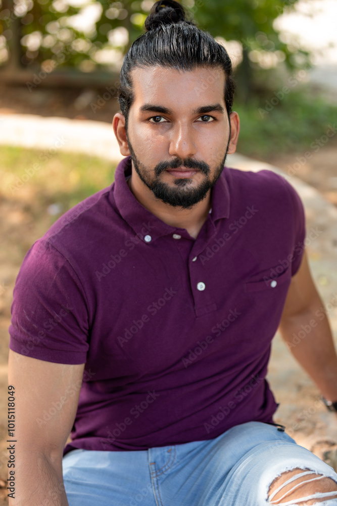 Close-up portrait of a confident, handsome, bearded Asian-Indian man with a ponytail. He faces the camera, showing a range of facial expressions and exuding a calm demeanor. Close-up portrait of a confident, handsome, bearded Asian-Indian man with a ponytail. He faces the camera, showing a range of facial expressions and exuding a calm demeanor.
