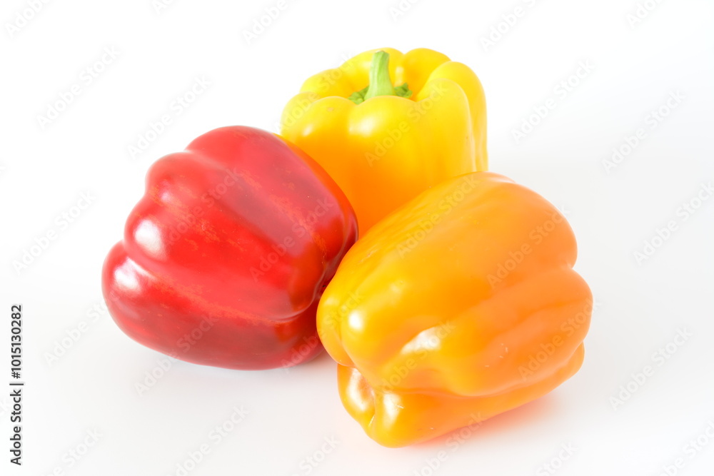 three red and yellow peppers are laying on a white surface three red and yellow peppers are laying on a white surface